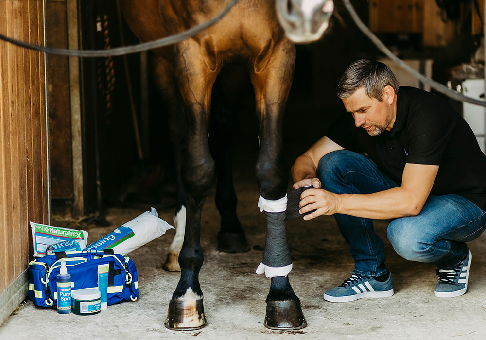 Christian legt einen Wundverband an mit Produkten aus der NAF NaturalintX Erste-Hilfe-Serie